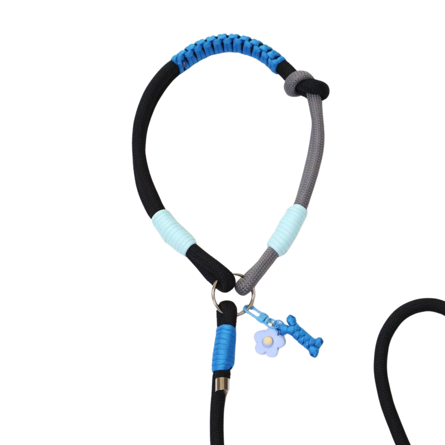 Close-up detail of blue and black slip lead dog handle showing paracord weaving, light blue wrapped sections and decorative flower charm attachment