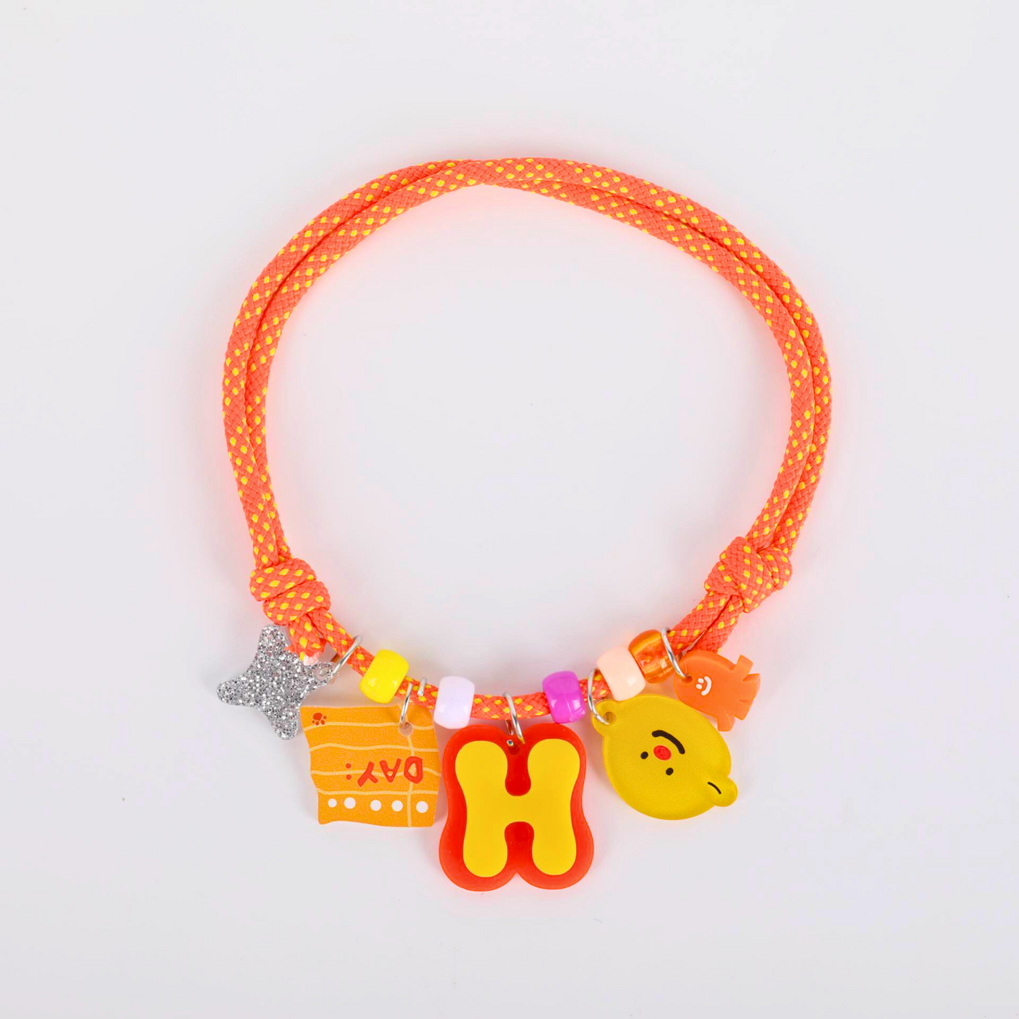 Neon orange dog collar with colorful charms on a light gray background