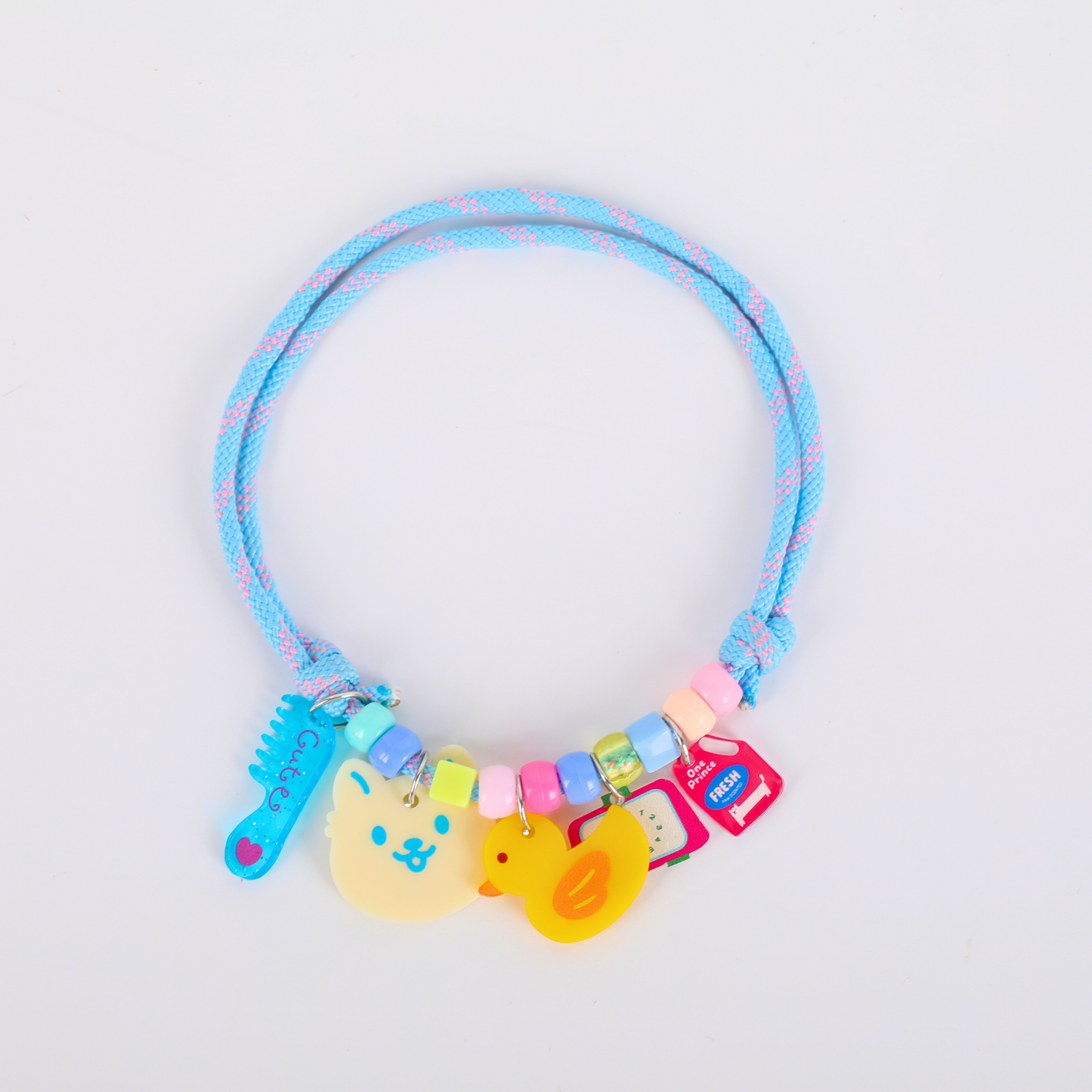 Colorful pet necklace with toys on a light gray background