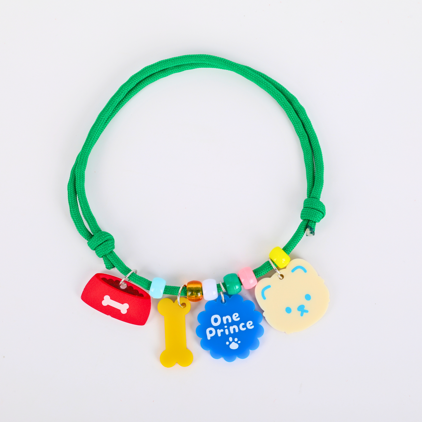 Green pet collar with colorful charms on a white background