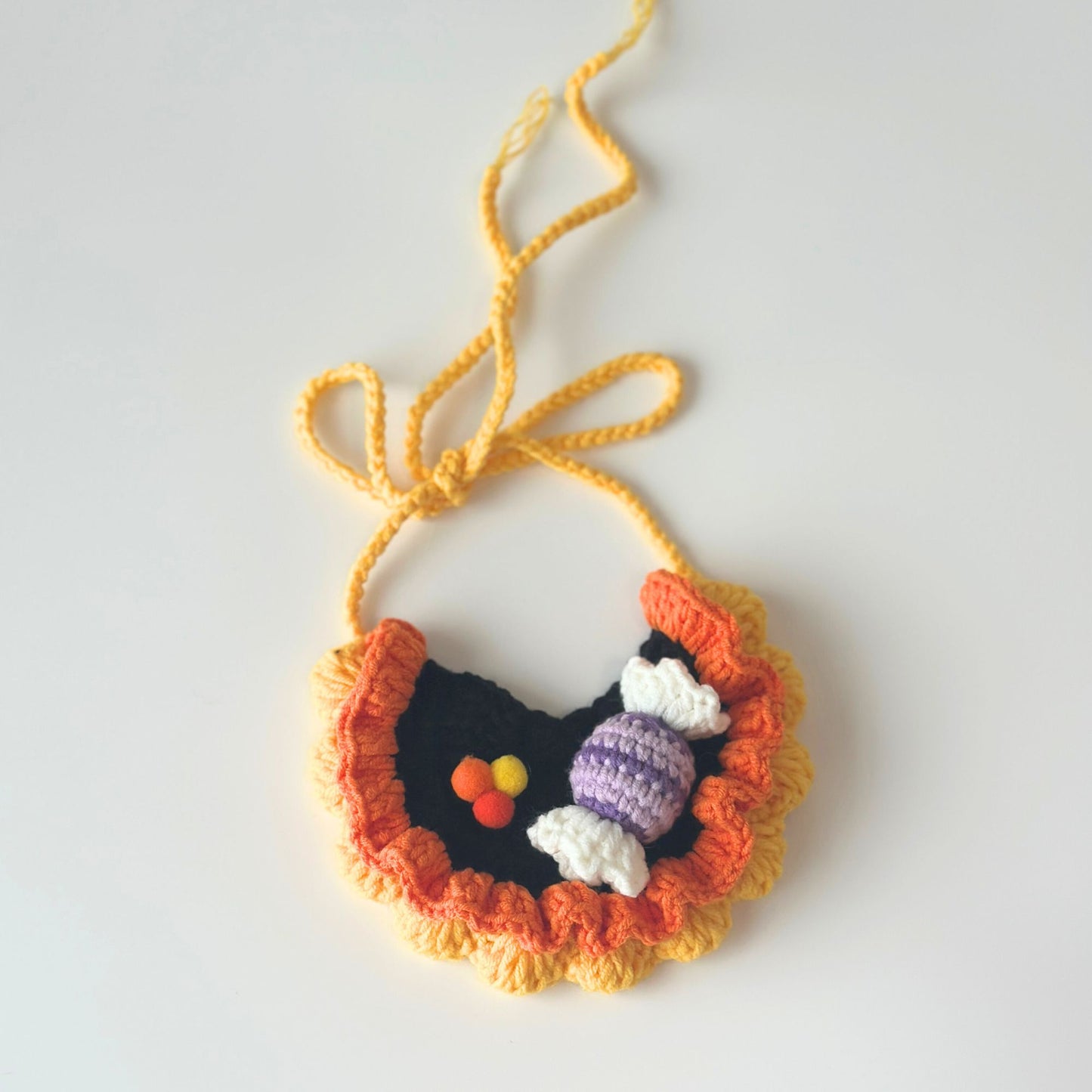 Crocheted necklace with colorful pendant on a white background