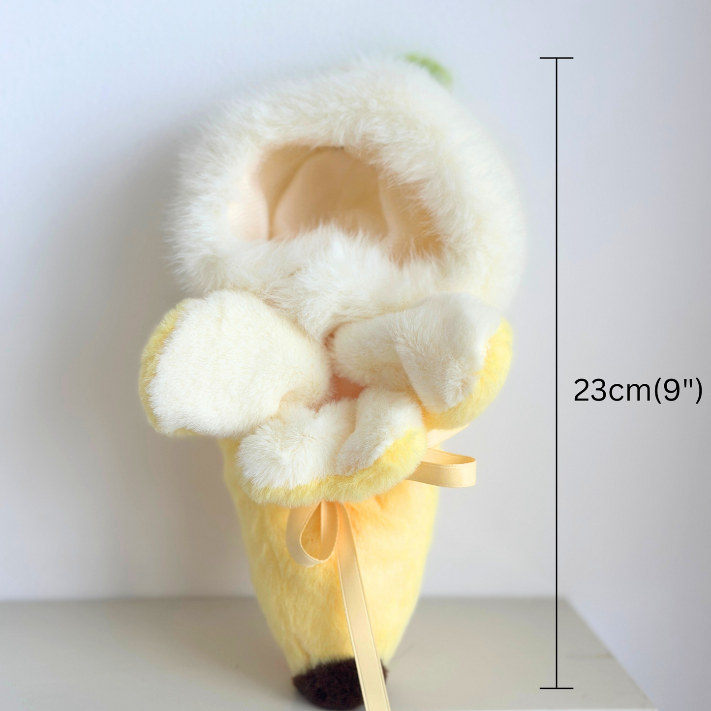 Side view of banana costume showing white fluffy hood and yellow body with ribbon ties