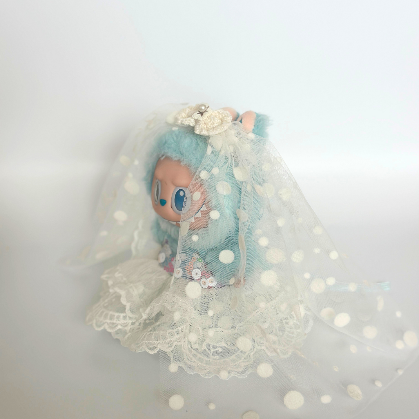 Labubu doll Hope wearing light blue polka dot wedding dress with white dots, bridal veil, flower hair accessories, and layered lace skirt