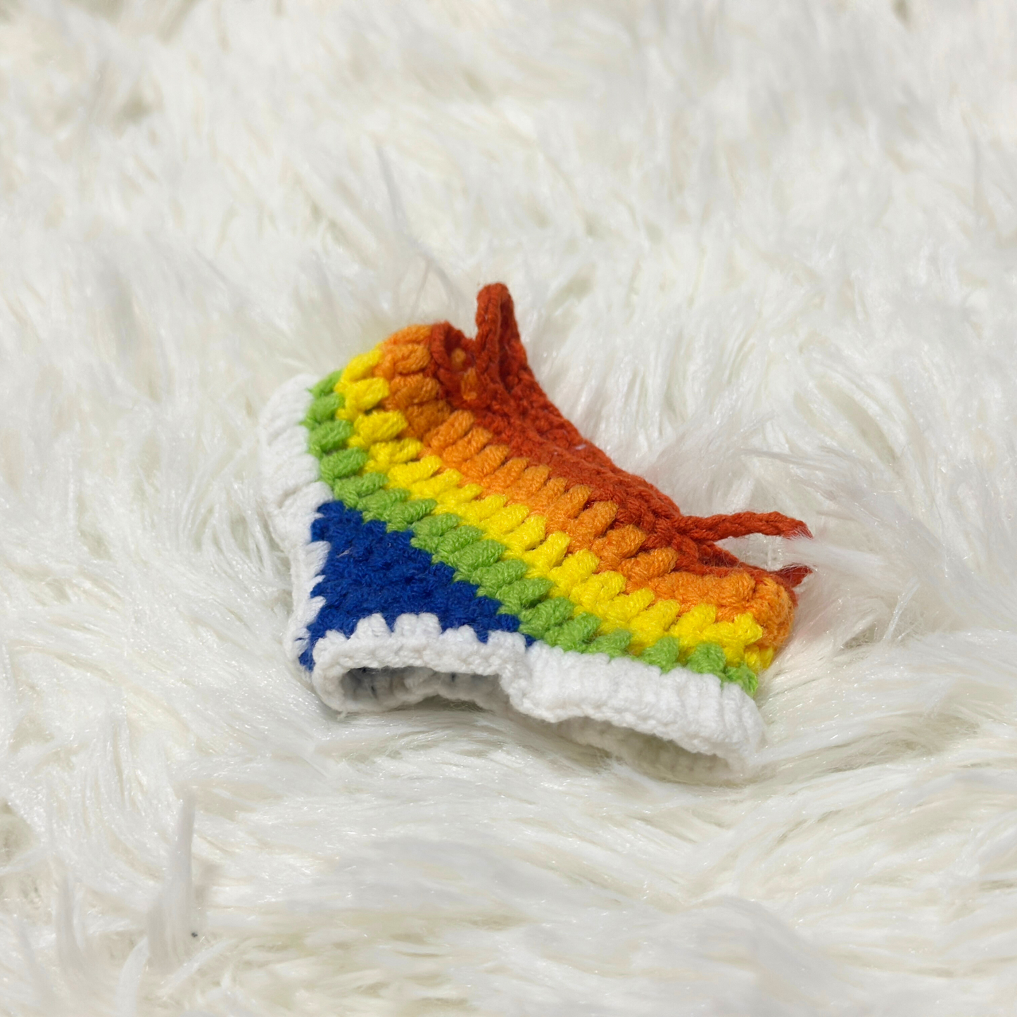Handcrafted rainbow striped dress for Labubu figure featuring textured crochet stitching and white ruffled borders, displayed solo on soft white background