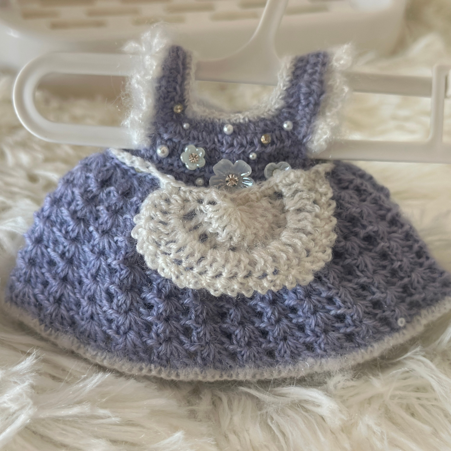 Crocheted labubu dress with purple and white colors on a hanger.