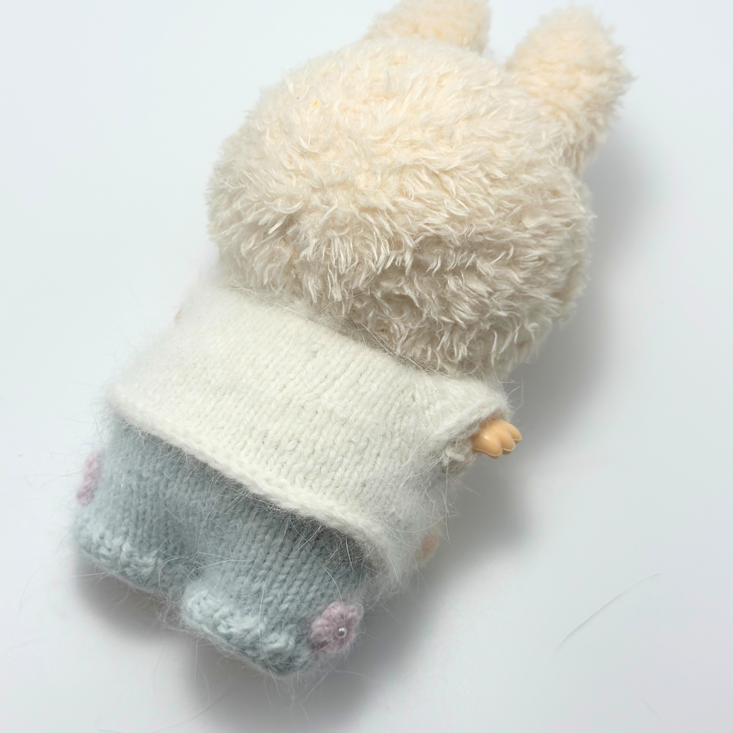 Back view of Labubu doll wearing white knitted bunny hoodie with fuzzy texture and light blue pants - handmade doll clothing showing rear perspective