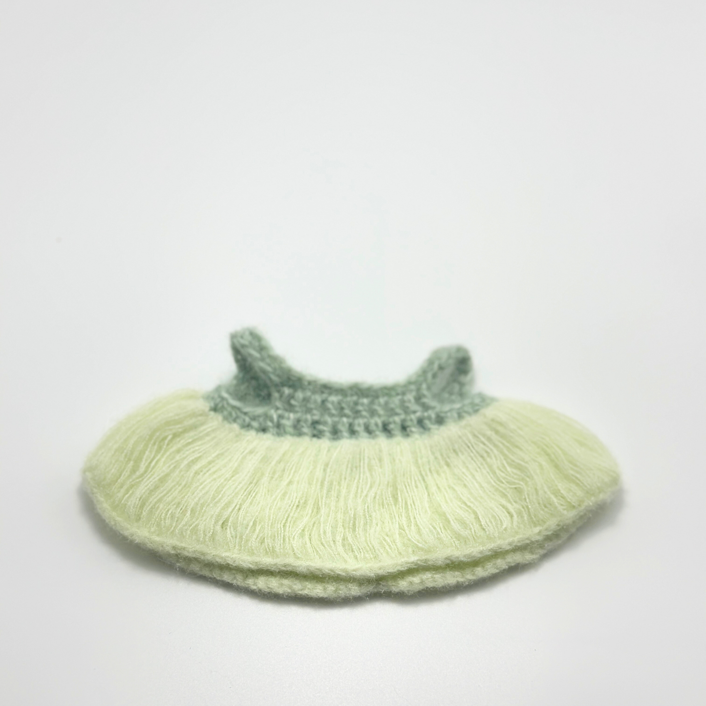 Knitted labubu dress with green top and light green bottom on a white background