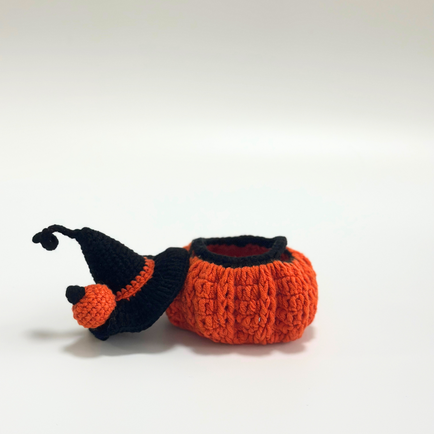 Separated components of handmade crocheted Halloween costume for Labubu doll showing black witch hat with curved tip and orange pom-pom beside orange textured pumpkin body with ribbed pattern and red interior lining. Displays individual construction quality of each piece, perfect collectible Halloween doll costume set for craft enthusiasts and toy collectors.
