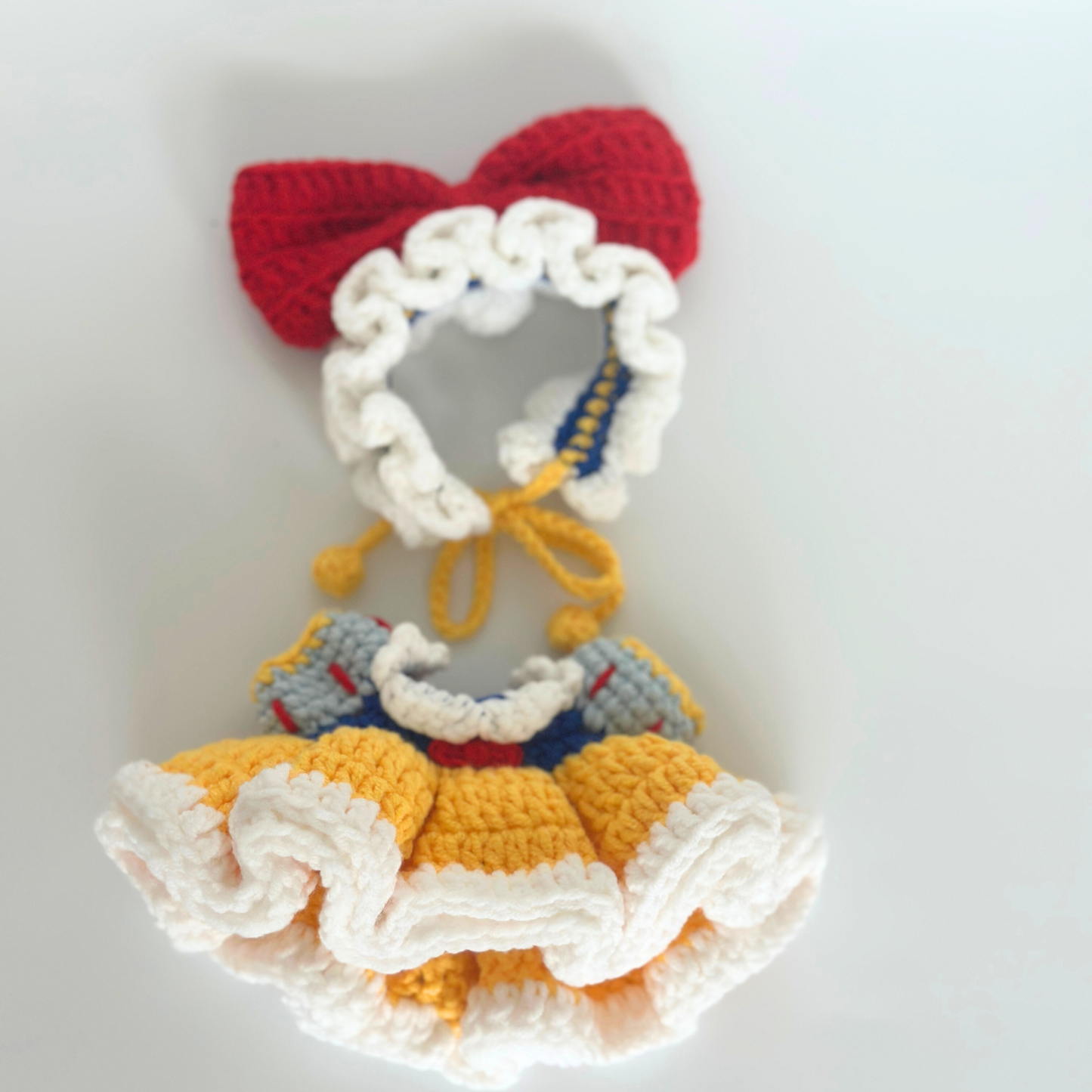 Complete handmade crocheted Snow White costume set for Labubu doll including red bow headband with white ruffled bonnet, blue bodice with gray puffy sleeves, yellow and white layered ruffled skirt, and yellow drawstring ties. Full doll costume set, collectible miniature clothing, DIY crochet pattern for toy collectors and handcraft enthusiasts.