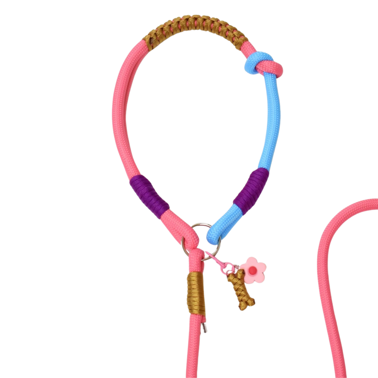 Close-up detail of colorful slip lead dog leash showing pink, purple, blue and brown paracord weaving with decorative wrapped sections, pink flower charm and bone charm