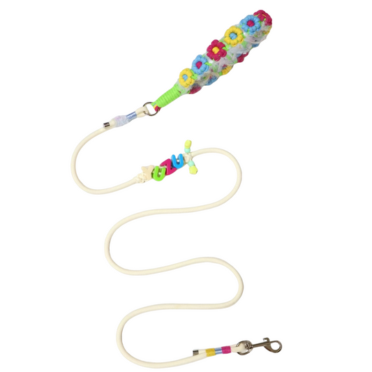 Colorful dog leash with white background featuring bright floral pattern in pink, blue, and yellow flowers with green grip handle