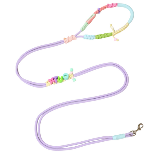 Custom handmade dog leash in pastel purple with personalized name 'HUGO' spelled in colorful letter beads, featuring rainbow macrame handle and adjustable design