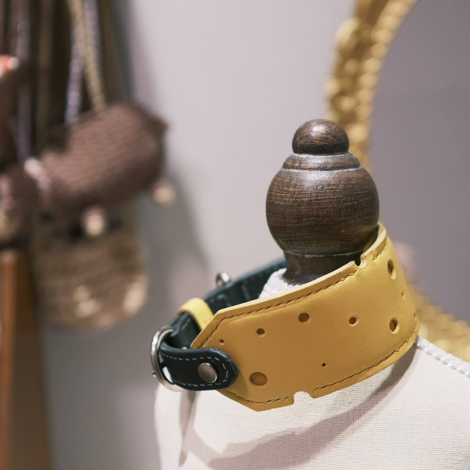 Premium cheese-shaped pet collar in yellow leather with black accents - unique dog collar displayed on wooden stand