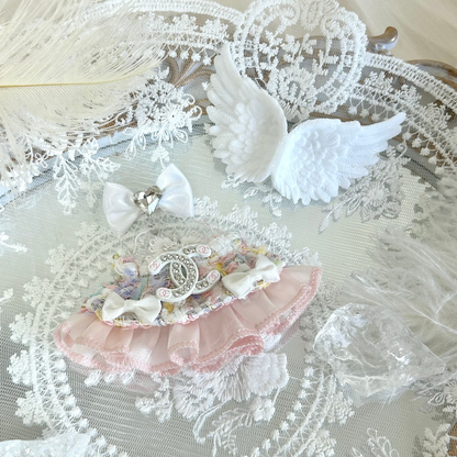 A delicate labubu 4.0 doll outfit featuring a white lace dress with pink satin ribbon trim and decorative chain detail, accompanied by white feathered angel wings, a white bow hair accessory, and crystal-clear transparent accessories, creating an elegant angel or princess-themed ensemble for doll dress-up.