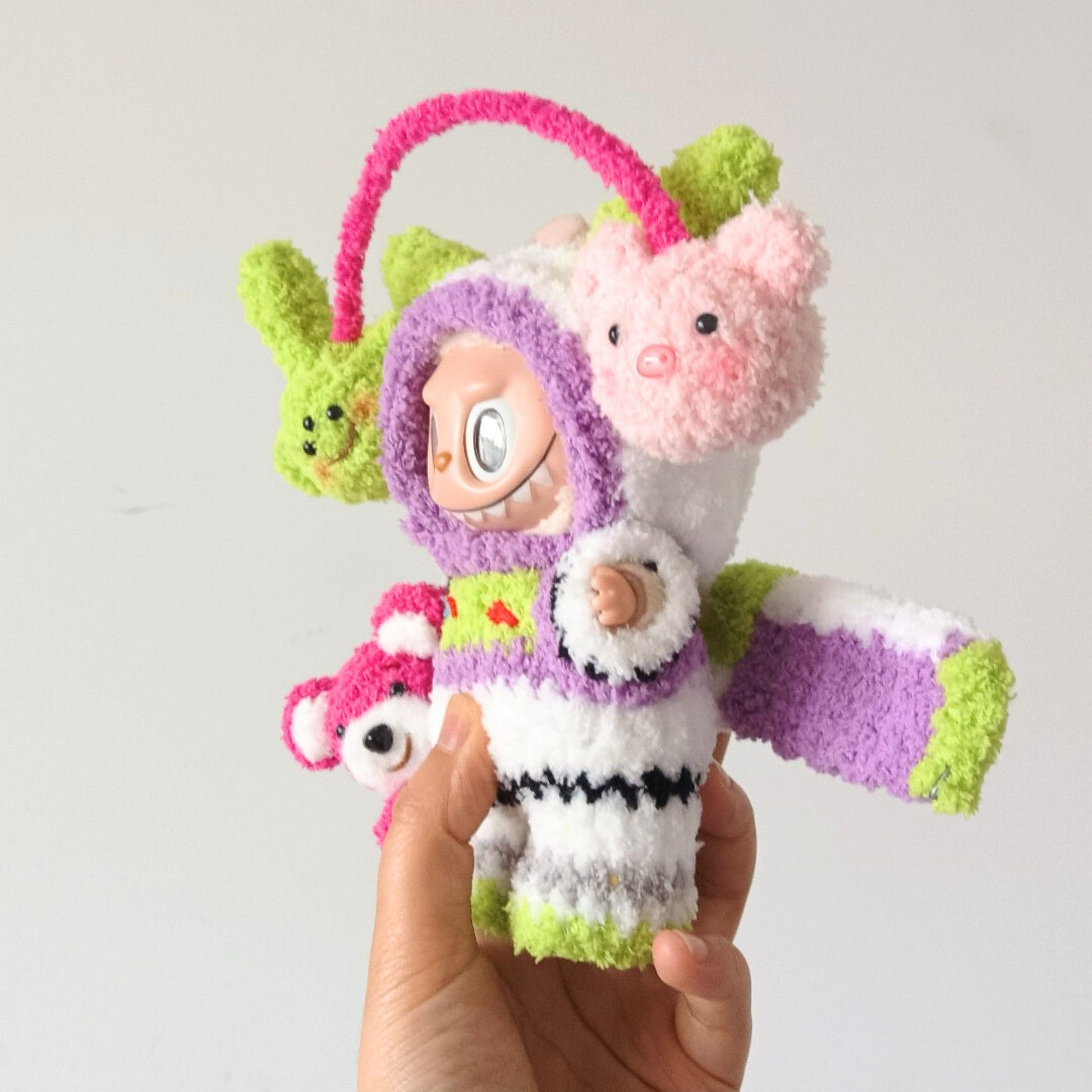 Labubu collectible toy in Buzz Lightyear outfit held in palm, showing purple space ranger costume with green alien and pink pig toy accessories for size reference