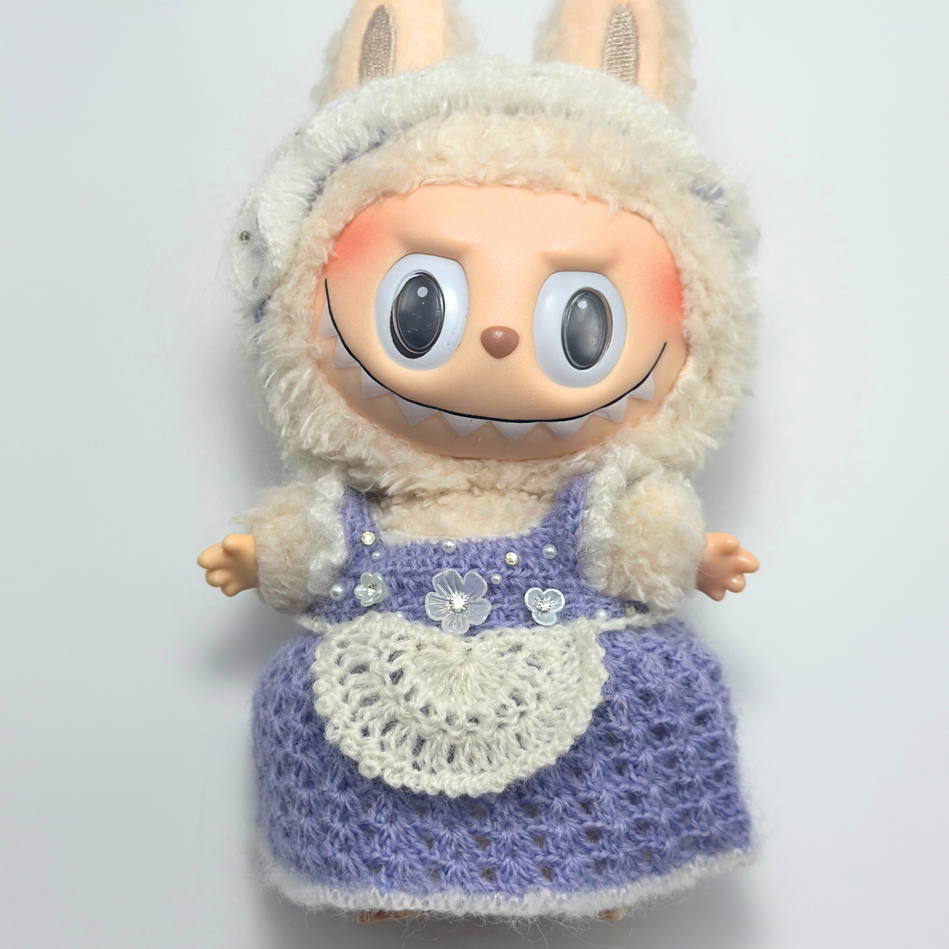 labubu with a knitted outfit on a plain background