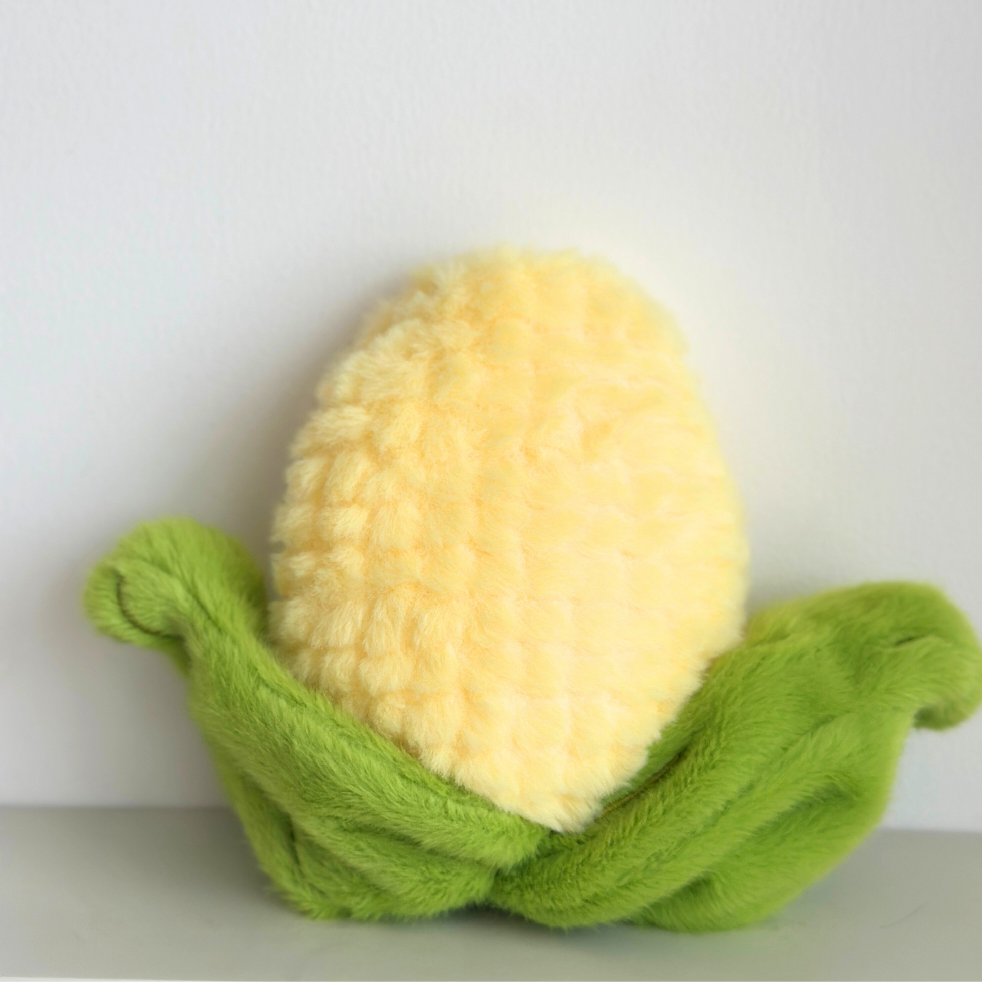 Back view of Labubu corn costume showing yellow fuzzy corn kernels head and green plush corn husk leaves spread out - rear perspective of vegetable-themed doll outfit components