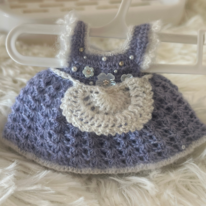 Crocheted labubu dress with purple and white colors on a hanger.