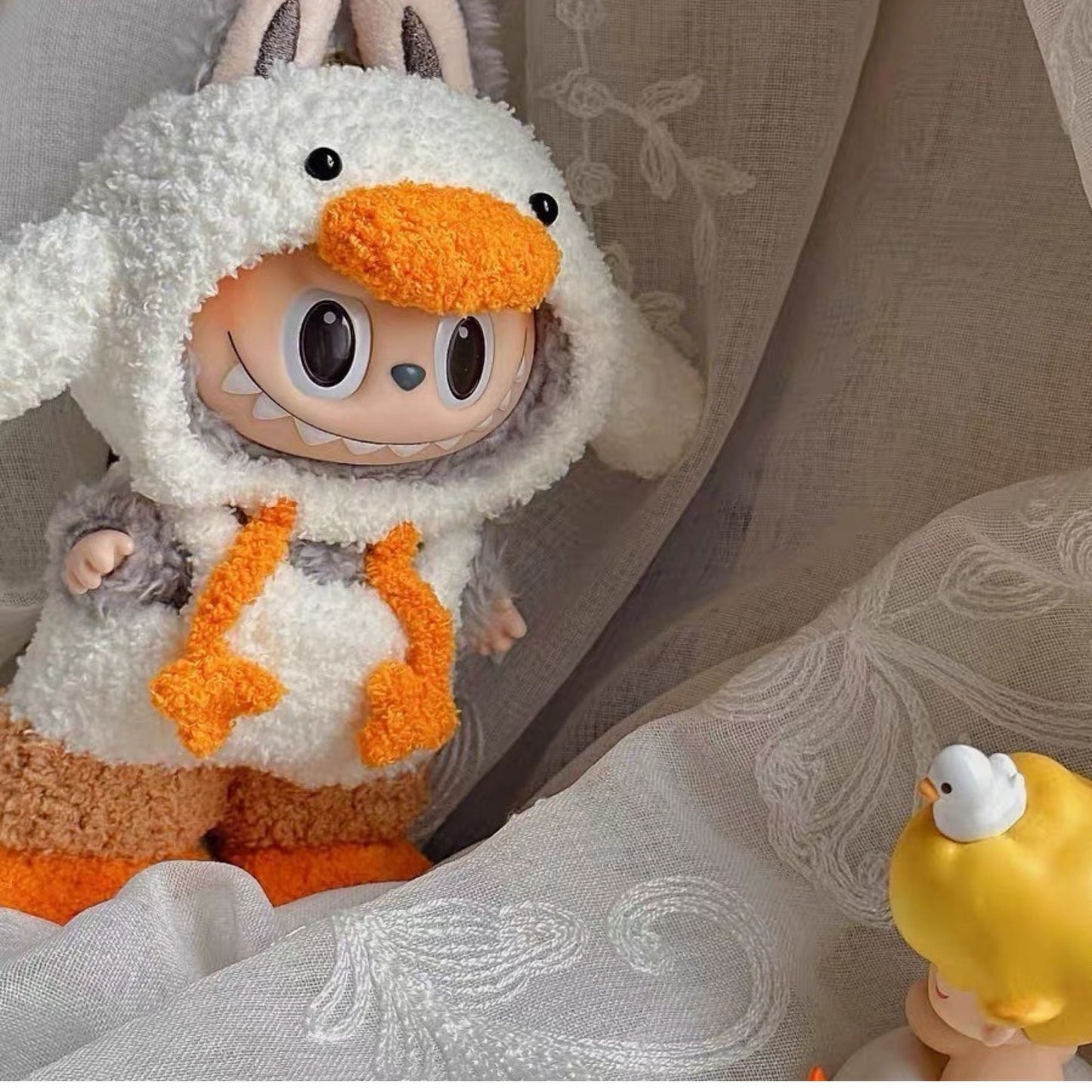 Labubu doll dressed in a fluffy duck hoodie outfit with orange details, handmade kawaii doll clothes