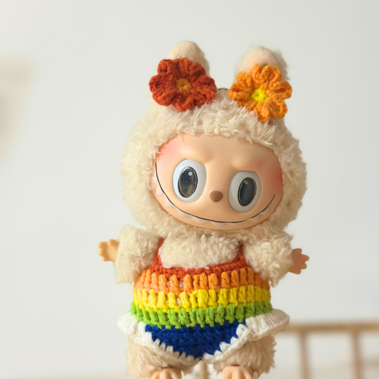 Adorable Labubu doll wearing a handmade rainbow gradient knitted dress with orange crocheted flower headband, showcasing detailed craftsmanship
