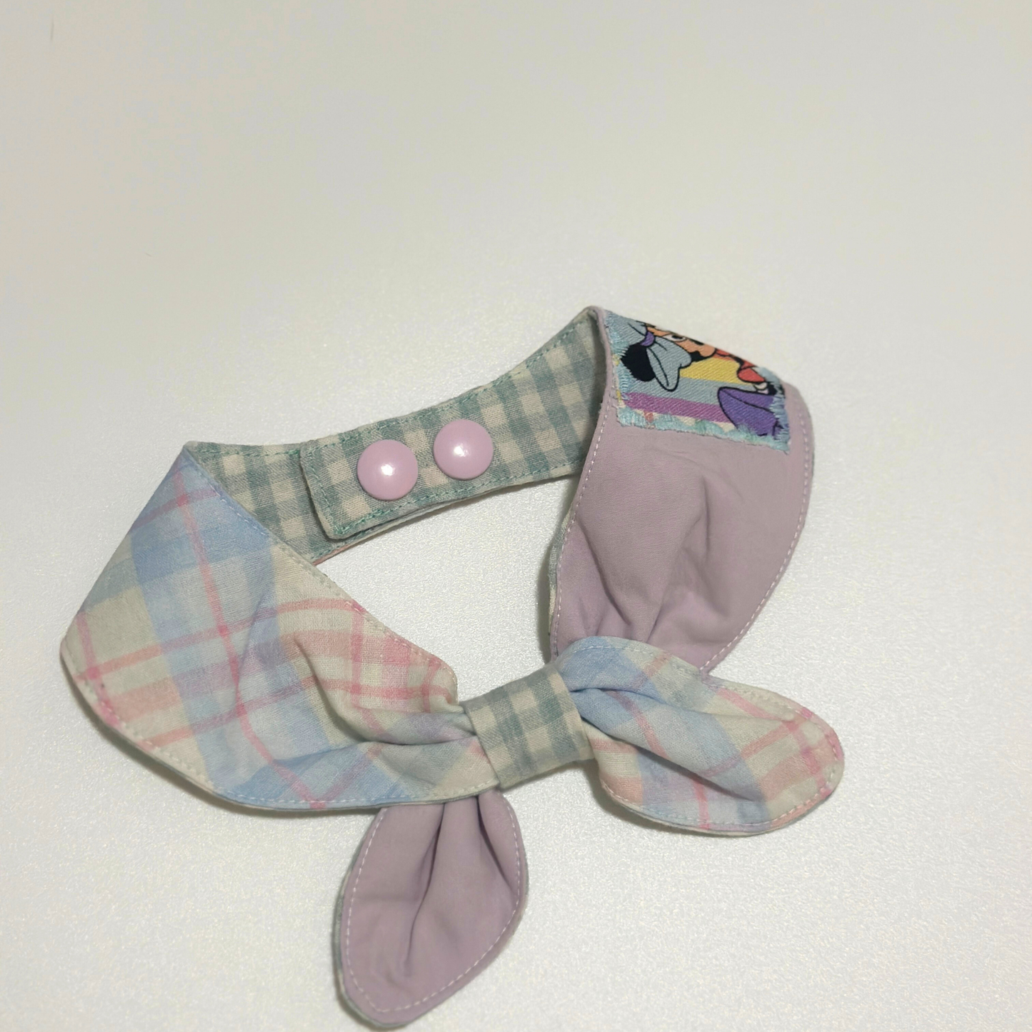 Pastel plaid dog collar with a bow on a white background
