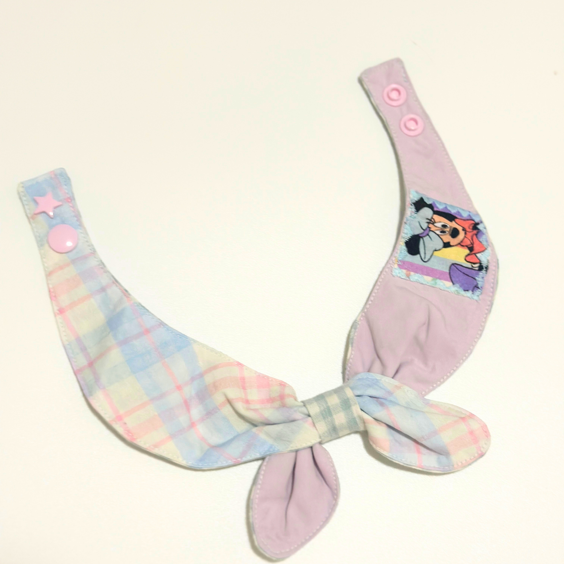 Pastel-colored pet bib with cartoon character on a white background