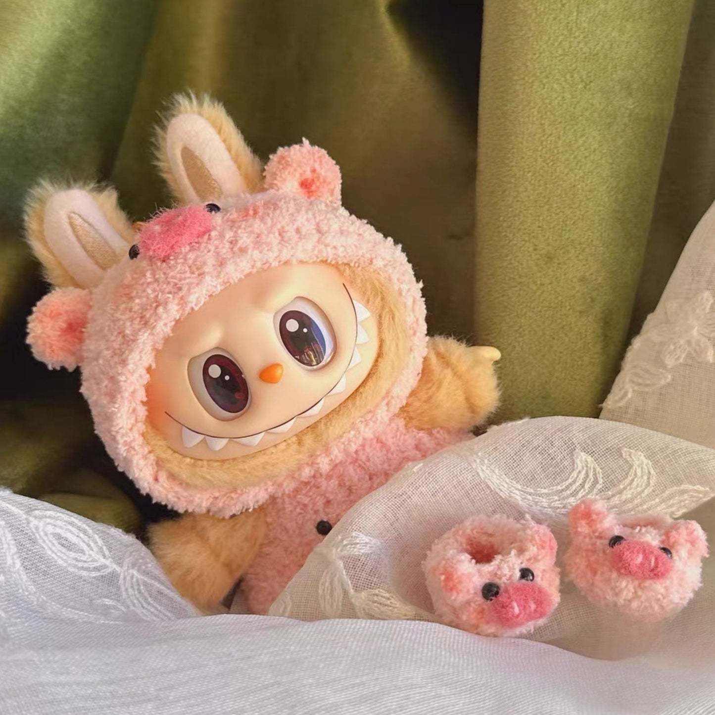 Labubu with pink pig ears and pig shoes on a soft surface