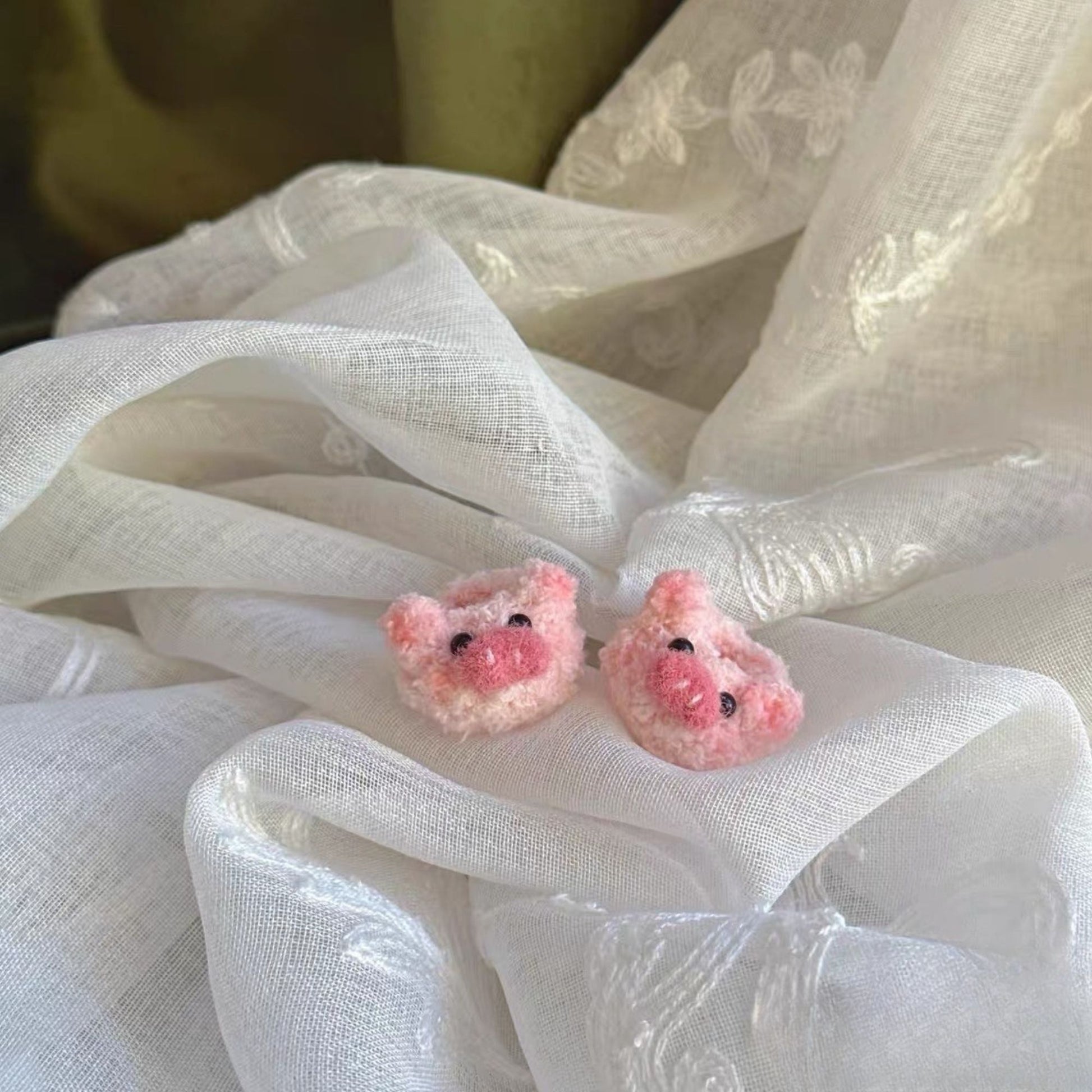 Pink bpig-shaped shoes for labubu  on a white fabric background